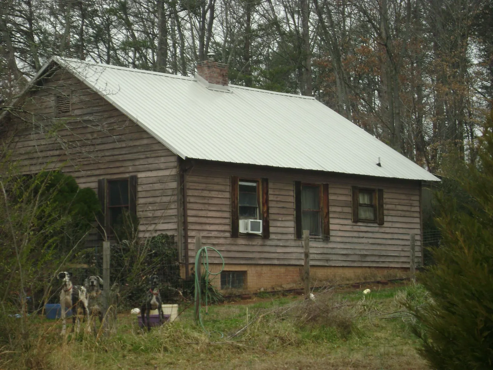 White metal roof on an old wood sided farmhouse, from a Metal Roof Installation job in Hays